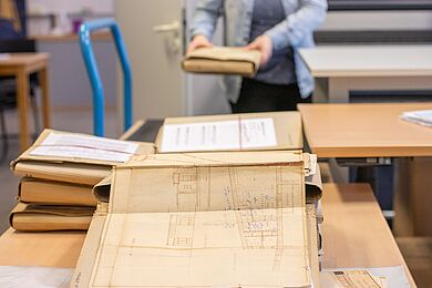 Verschieden Bauakten liegen auf einem Arbeitsplatz.